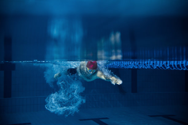 专业男性游泳运动员在室内游泳池训练时的动作和动作的水下视图。健康的生活方式，动力，能量，运动理念图片下载