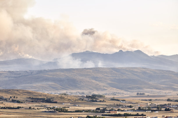 在一个城市附近的山坡上，一场森林大火和一大片烟雾的照片。自然灾害的概念图片下载