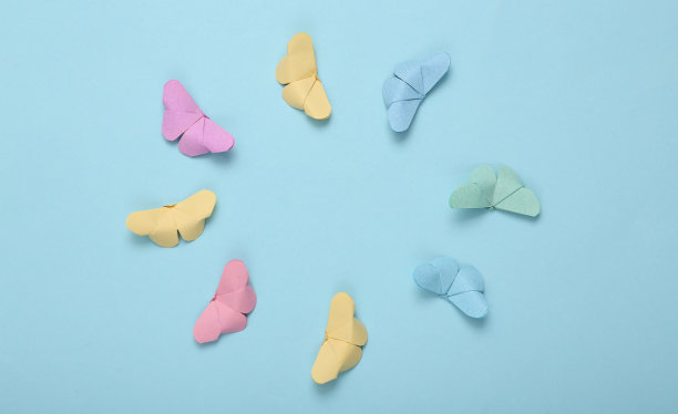 折纸蝴蝶在蓝色背景上盘旋图片下载