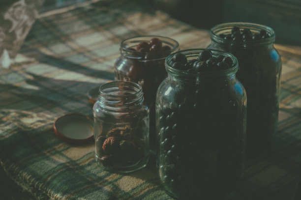 在玻璃罐里收获浆果。黑醋栗，樱桃，草莓。乡村风格，深色照片，复制空间，水平构图图片下载