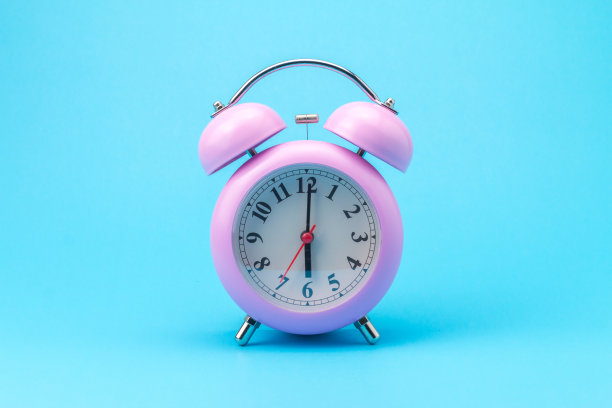 蓝色背景上的粉色闹钟图片下载