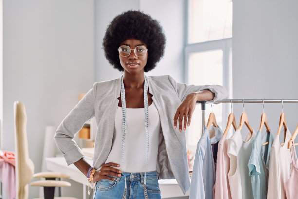 漂亮的年轻非洲女人靠在衣架上图片下载