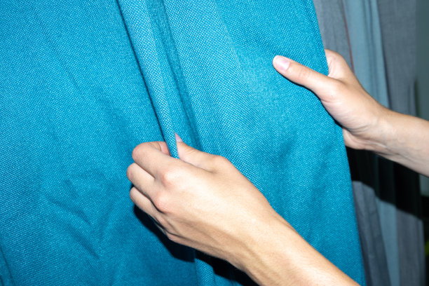 女人们在挑选蓝色的布料缝制衣服。在商店和网上销售面料的概念。图片下载