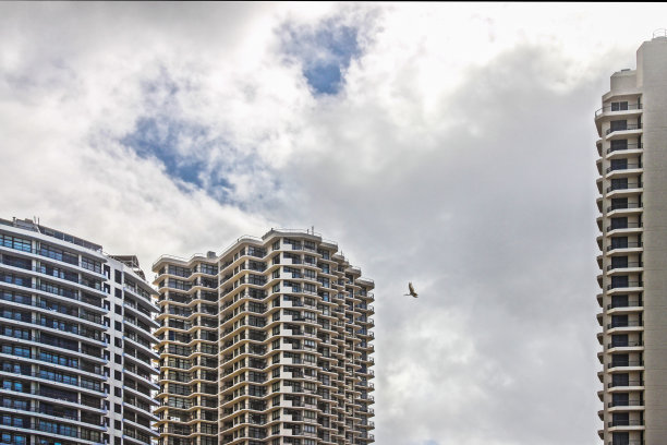 高耸入云的摩天大楼高耸入云，起重机在大楼之间飞得很高。图片下载