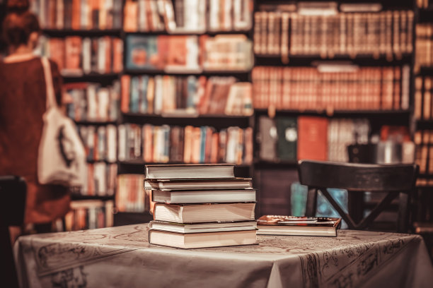 图书馆里一堆书的特写。抽象女孩的剪影。教育，重返学校，阅读。模糊的背景图片下载