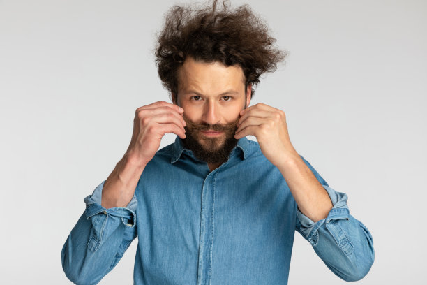 英俊的大胡子男人，穿着牛仔衬衫，修剪着小胡子图片下载