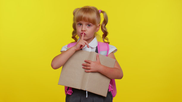 嘘请安静，小学生女孩按手指到嘴唇做沉默手势，不泄密图片下载