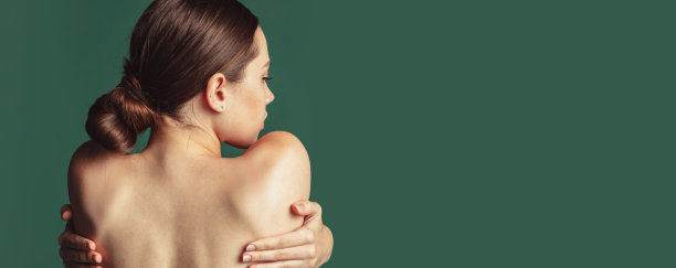 后视图裁剪的图像年轻的女孩抱着肩膀孤立在绿色背景。关怀的概念图片下载