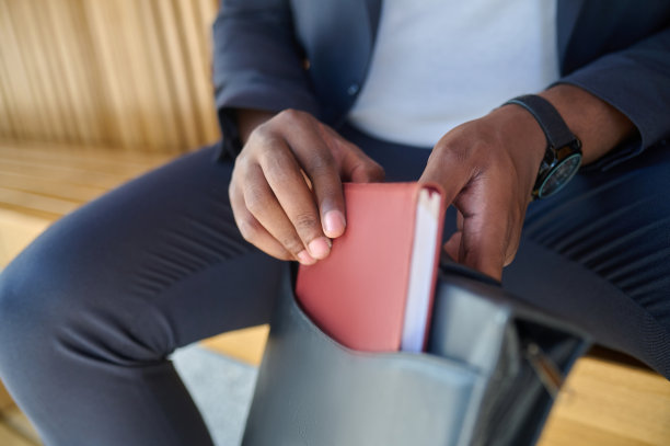 一名男子手拿笔记本的特写照片图片下载