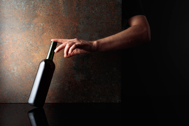 手伸向一瓶红酒。图片下载