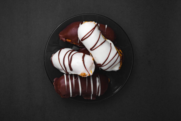 巧克力脆饼。传统的巴西éclair，黑色背景上填充巧克力或牛奶。图片下载