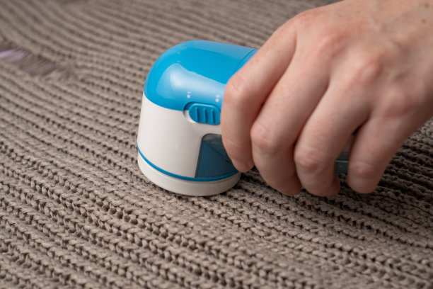 蓝色织物剃须刀针织毛衣背景。尘器。衣服刮胡刀装置图片下载