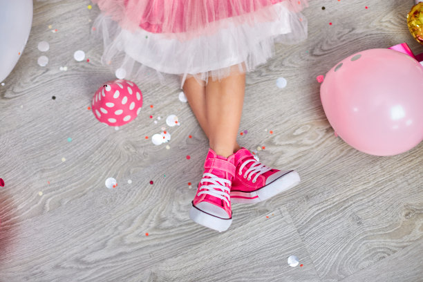 穿着粉色运动鞋和裙子的女孩的腿创造性地摆出来，平摆图片下载