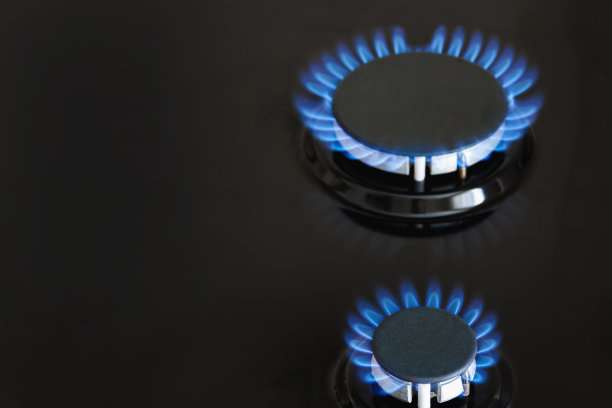 深色的炉子上，两个煤气炉在燃烧着蓝色的煤气灯。特写镜头,有选择性的重点图片下载