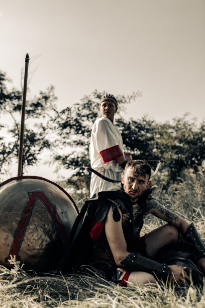 古代战士和女弓箭手在盾牌和长矛旁休息。图片下载