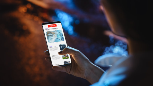 美女在使用智能手机，查看社交媒体上满是新发布的照片。一位匿名女性漫步在霓虹灯闪烁的夜城街道上。查看话机屏幕图片下载