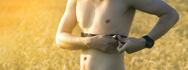 一名年轻的男运动员戴上了心率监测器。图片下载