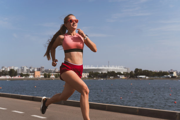 一个长头发的可爱的运动女人在体育场跑步图片下载