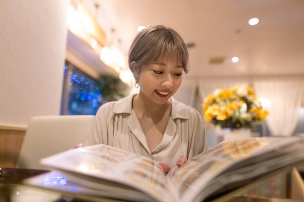 一名年轻女子在一家亚洲餐厅看菜单图片下载