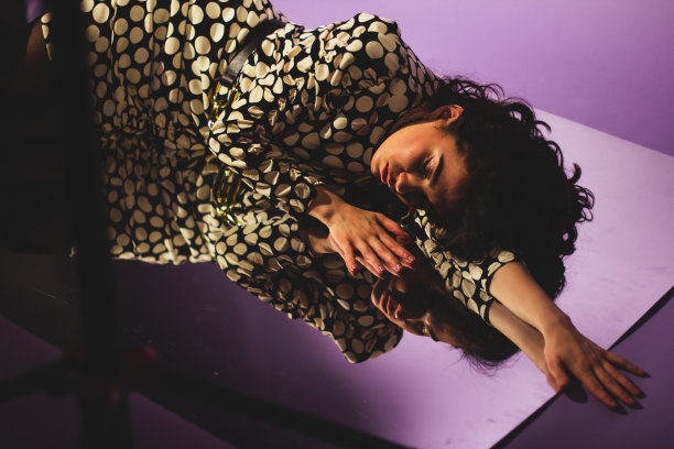 镜子上放着一张漂亮女人的时尚照片，深色头发，穿着带有圆点的裙子。图片下载