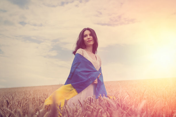 拿着乌克兰国旗的漂亮女孩在麦田里闲晃图片下载