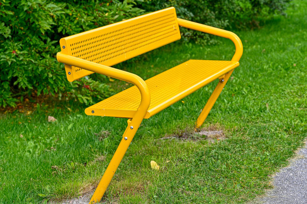 公园里黄色的金属长凳图片下载