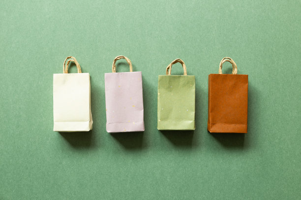绿色背景上的纸袋。俯视图，复制空间图片下载