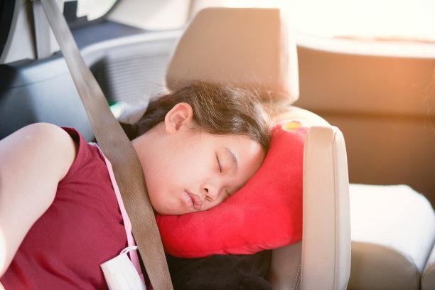 亚洲女孩小孩睡在车里用枕头和安全带安全乘坐汽车旅行的概念图片下载