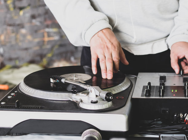 在嘻哈派对上播放音乐的DJ。模拟转盘，Dj使用转盘和混音器刮擦。图片下载