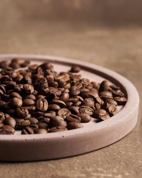 咖啡豆特写。咖啡在棕色背景上的微距摄影。一个地方的文字在食物照片。阿拉比卡。图片下载