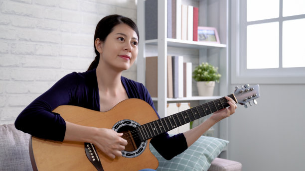 女人一边弹吉他一边微笑图片下载