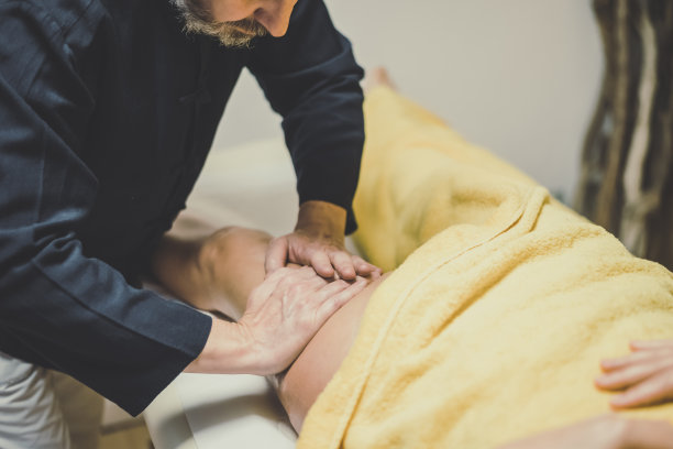 男人在健身中心按摩女人的柔和聚焦视角。涂油的手放在身体上，放松肌肉，缓解紧张。健康幸福的概念图片下载