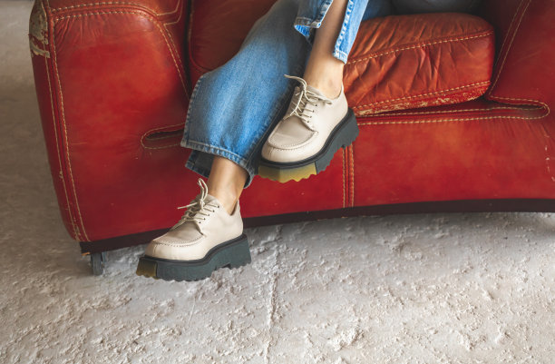 红色扶手椅复古风格和少女休闲装，牛仔牛仔裤和运动鞋。时尚复古照片图片下载