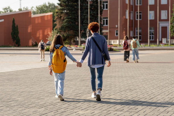 年轻的女性和她的女儿背着背包走下大广场图片下载