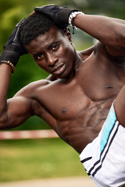 一个黑人运动员在做腹部运动，一个非裔美国运动员在公园的操场上锻炼在一个自豪的环境中图片下载
