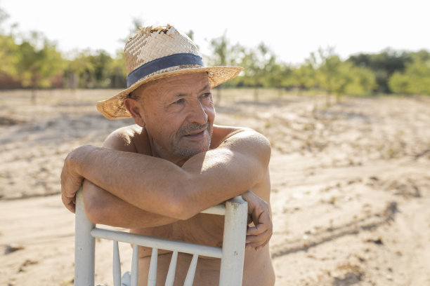 老农戴着帽子坐在椅子上图片下载