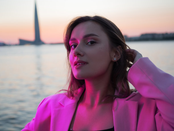 一个年轻时尚的黑发女郎在夜城的霓虹灯下，图片下载