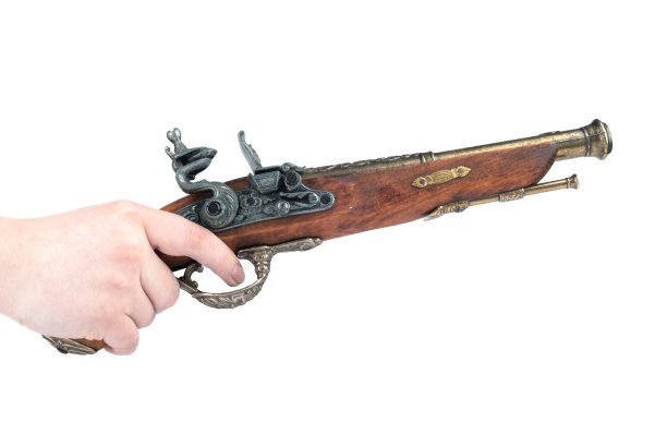 人的手在一个旧手枪模型的扳机上。图片下载