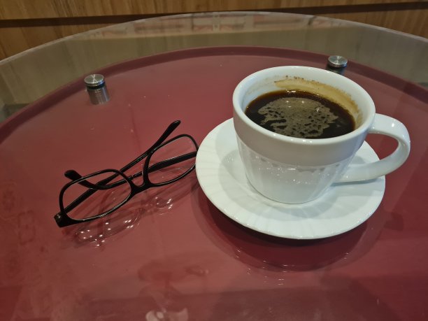红桌子上放着一杯黑咖啡和玻璃杯图片下载