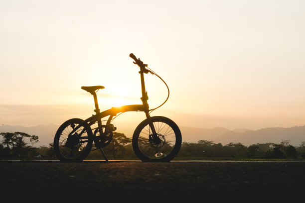 以日落为背景的折叠自行车的剪影图片下载