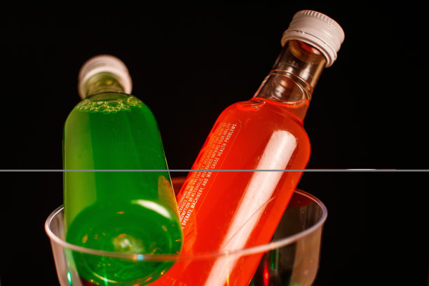 在黑色背景下，两个酒瓶放在一个鸡尾酒杯里图片下载