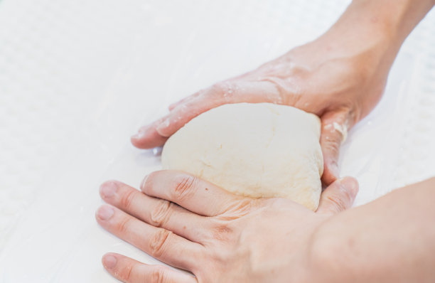 一个人揉面团的照片。制作面包和披萨的图像。图片下载