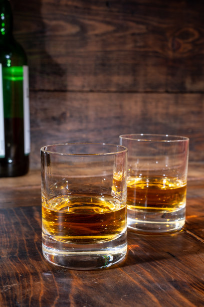 在古老的酒吧里，深色木桌上摆着几杯浓烈的苏格兰纯麦芽威士忌图片下载