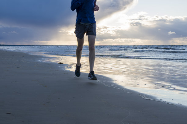 一个慢跑者为了跑马拉松，在清晨跑过海滩图片下载
