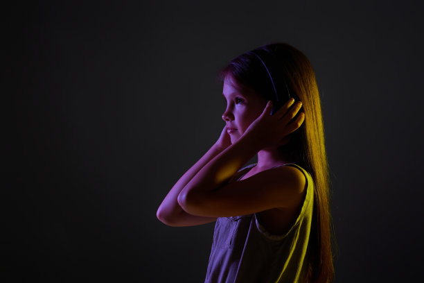 可爱的小女孩戴着无线耳机听着音乐图片下载