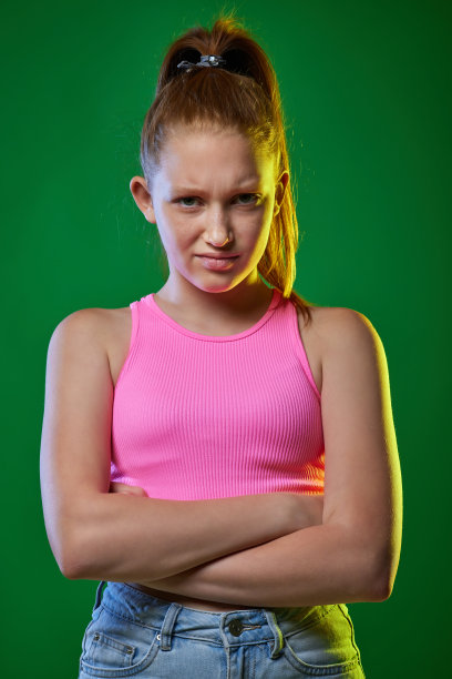 不满的红发少年在绿色背景上。图片下载