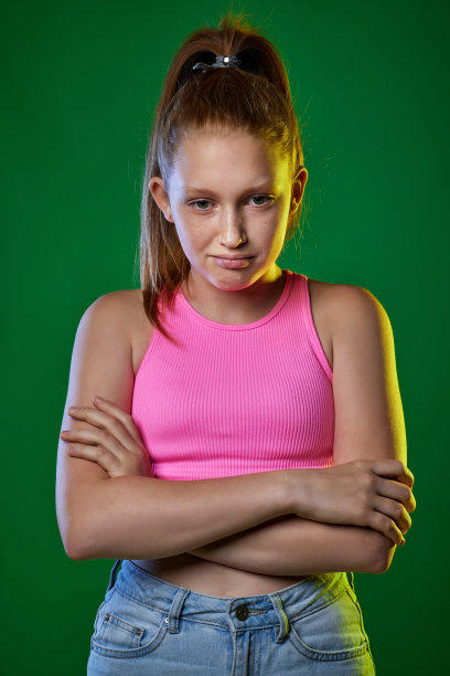 不满的红发少年在绿色背景上。图片下载