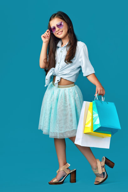 快乐的白人小女孩拿着很多购物袋图片下载