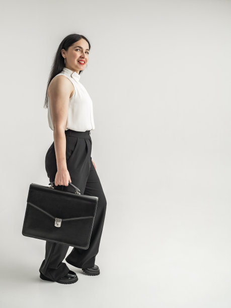 一个拿着公文包的漂亮女商人的肖像。年轻时尚的女商人，长卷发图片下载