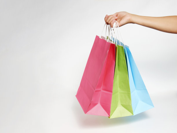 女人手拿购物袋在白色的背景图片下载